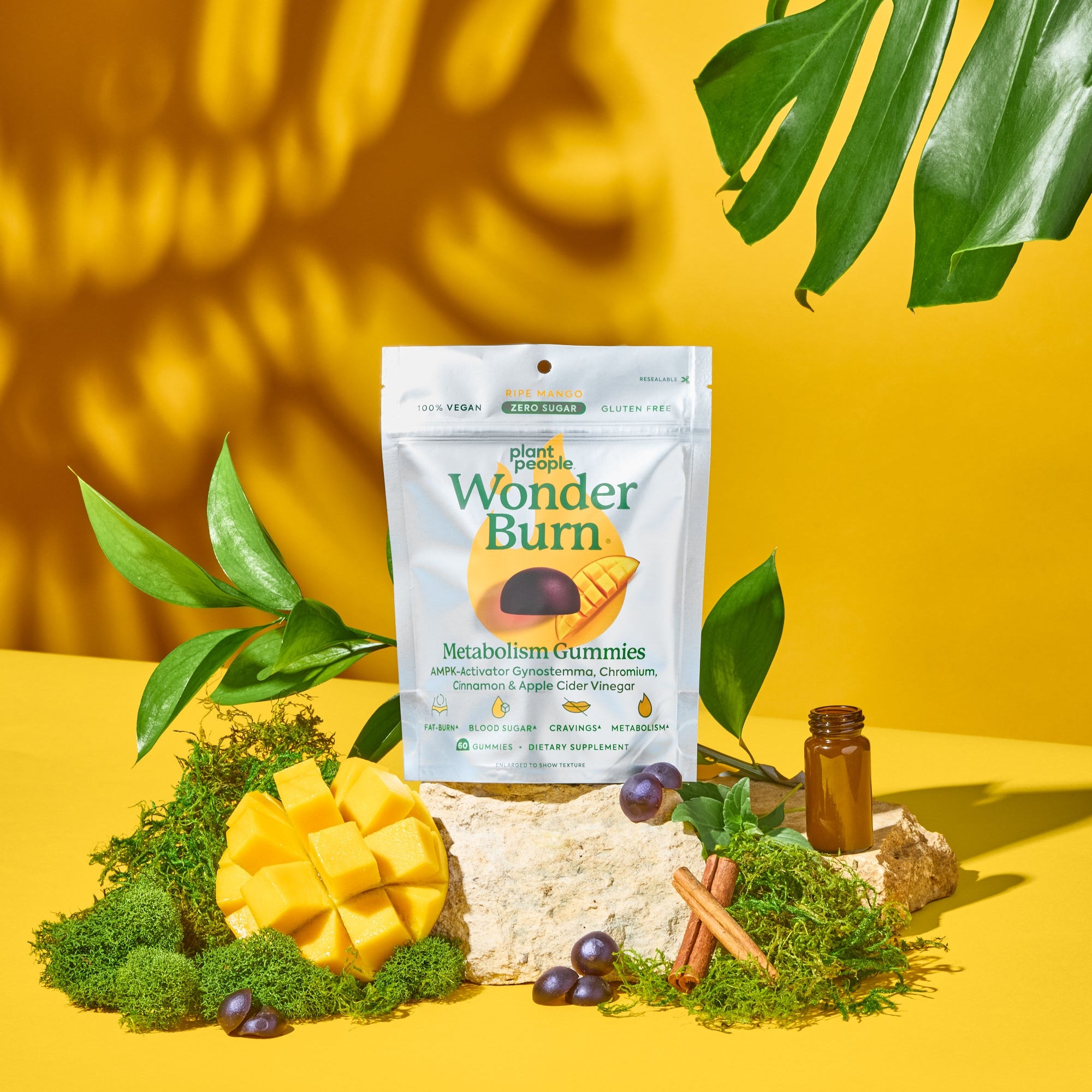 Package of Wonder Burn gummies on a yellow background with greenery
