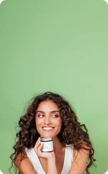 women holding plant people's product under her chin and smiling