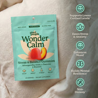 Plant People Wonder Calm Stress & Balance Gummies pouch in peach flavor, displayed on a soft white fabric background with green benefit callouts on the right.