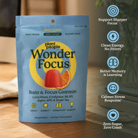 Plant People Wonder Focus Brain & Focus Gummies in a light blue stand-up pouch, shown on a wooden surface with a blurred indoor background and a vertical list of benefits on the right.
