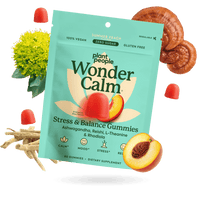 Plant People Wonder Calm Stress & Balance Gummies in a bright teal pouch, surrounded by peach slices, red gummies, a yellow flower, and mushroom slices on a white background.