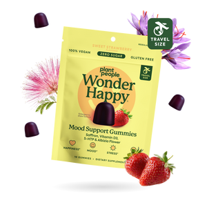 Plant People Wonder Happy Mood Support Gummies in a travel-size pouch, shown with three dark purple gummies, fresh strawberries, and flowers on a white background.